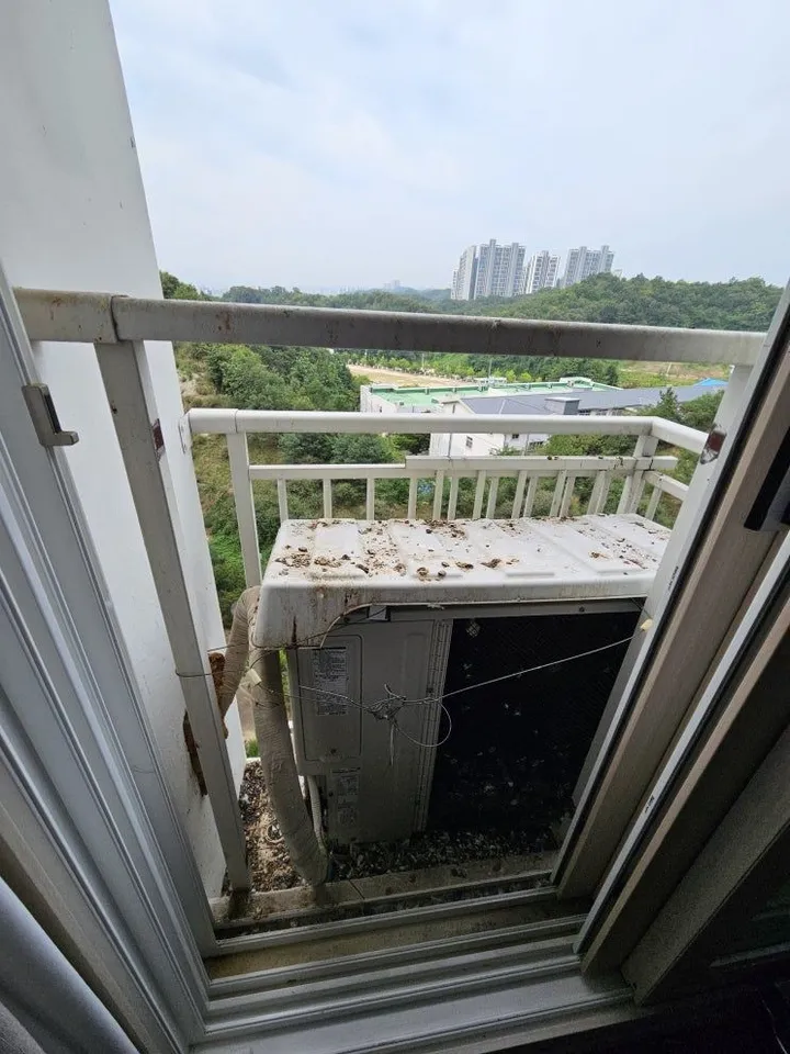 난간과 실외기가 있는 아파트 실외기실을 창가에서 찍은 전체 사진 예시