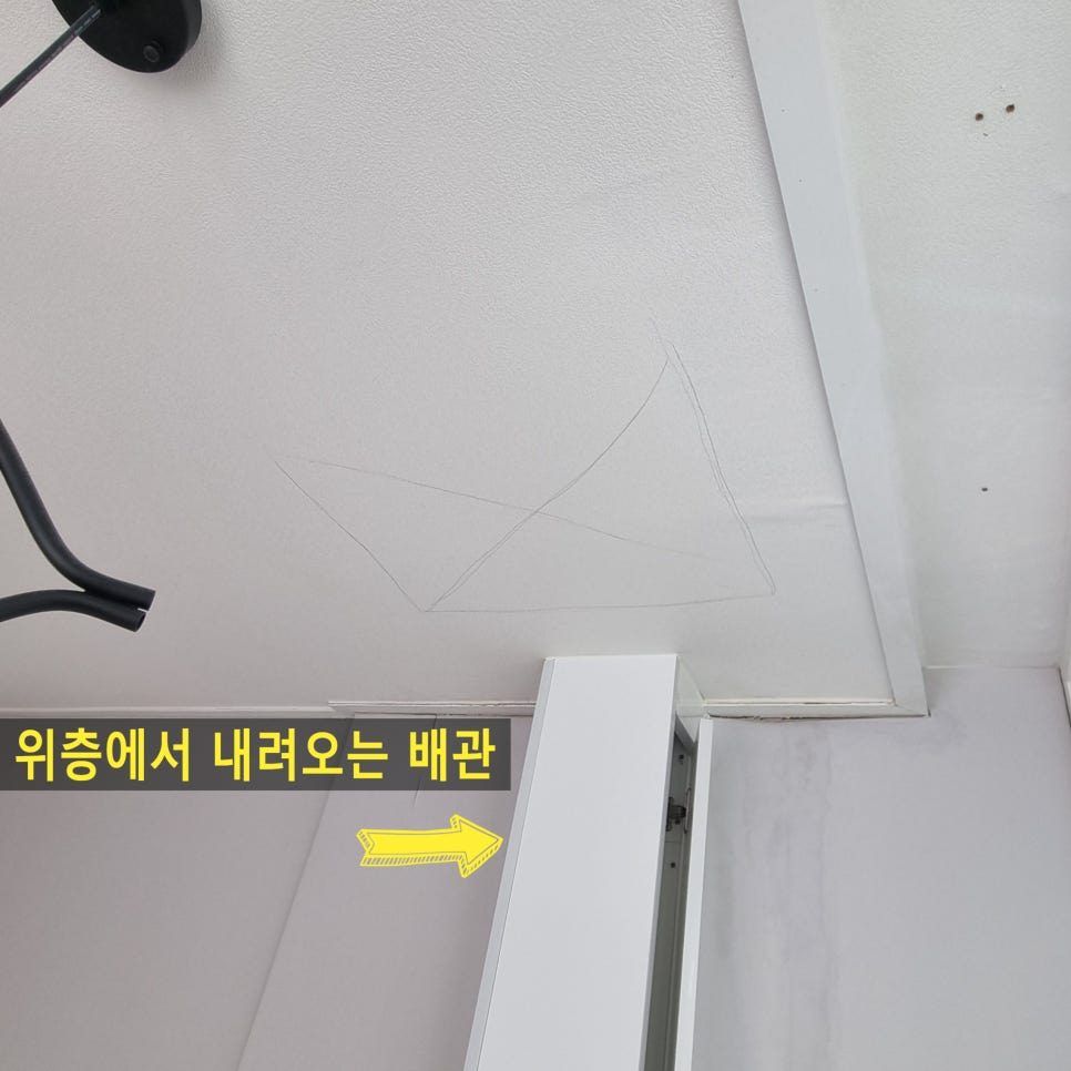 시공 전 — 위층에서 내려오는 배관이 벽면으로 돌출된 천장
